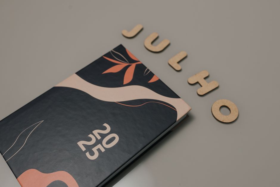 A 2025 planner with a modern design, next to wooden letters spelling 'Julho'.