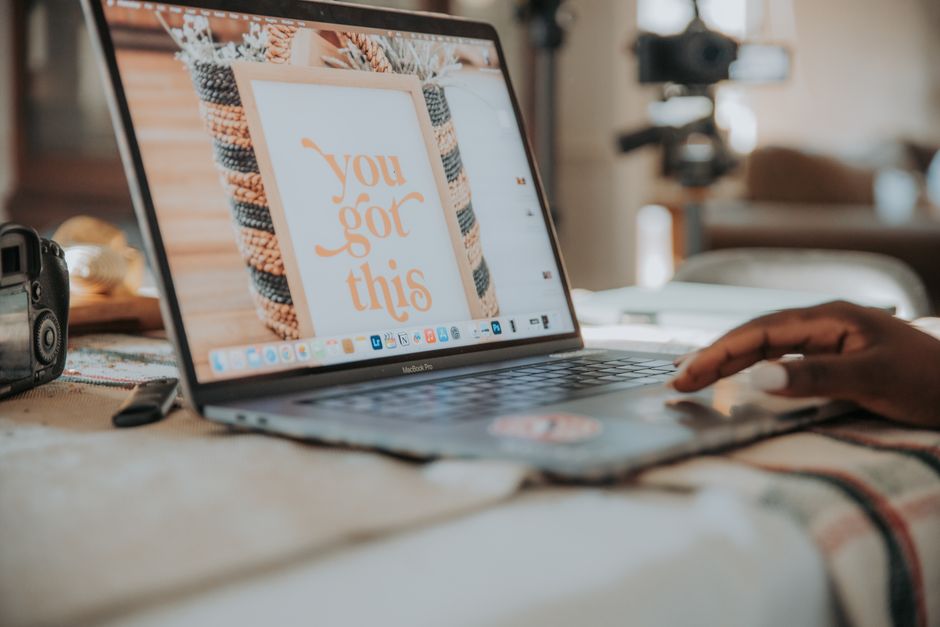 A laptop on a table displays an inspiring message,