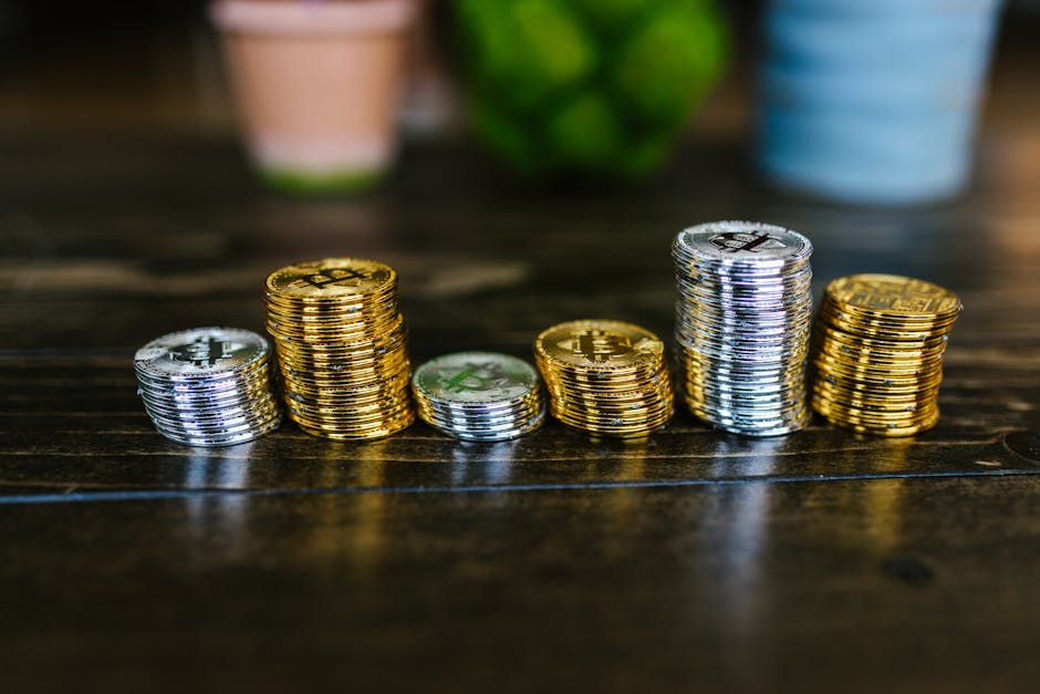 Pile of shiny gold and silver cryptocurrency coins on a wooden table.