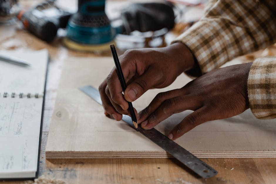 Close-up of a craftsman accurately measuring and marking wood in a workshop.